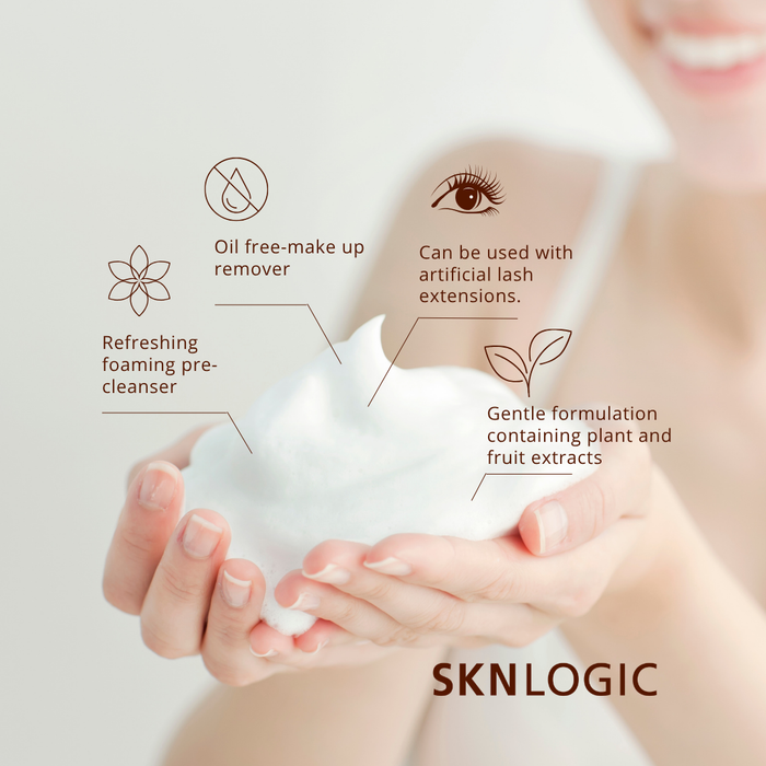 SKN128 SKNLOGIC Makeup Remover Oil Free 200ml | A close-up of a person holding a dollop of white foaming skincare product in their hands, with text callouts listing benefits such as oil-free makeup remover, refreshing foaming pre-cleanser, gentle formulation, and compatibility with artificial lash extensions. The brand name SKNLOGIC appears at the bottom.