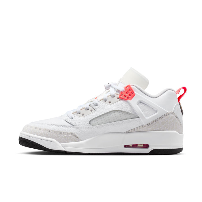 White low-top sneakers with red midfoot patch, textured overlays, and cushioned sole