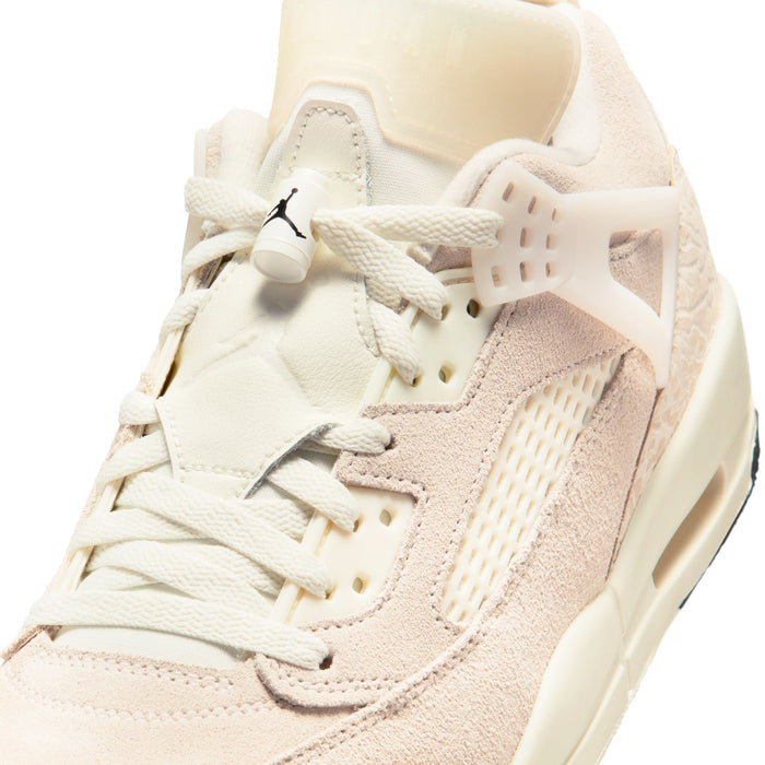 Close-up of cream lace-up sneakers with white tongue and small black Jordan wing logo