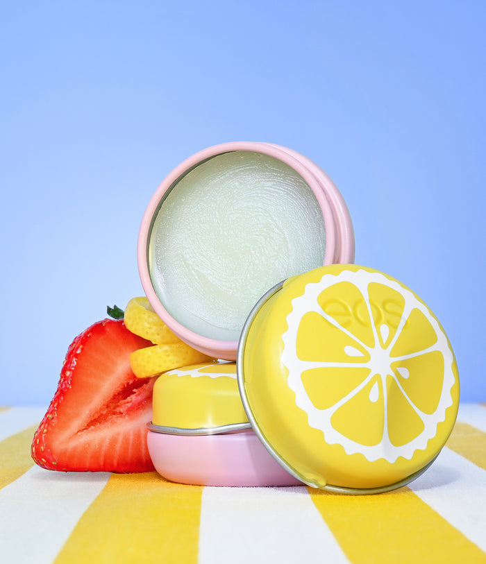 Cosmetic containers with strawberry and lemon design on a striped background