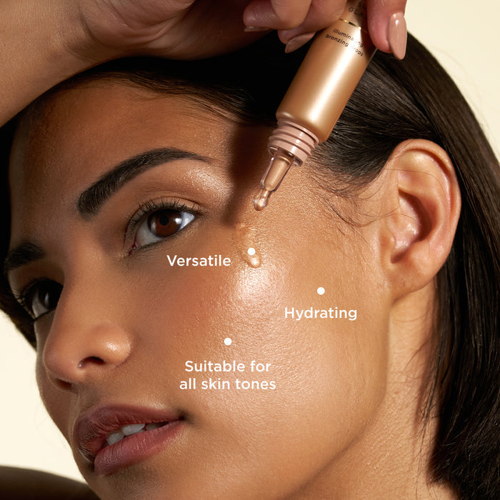 The image shows a woman applying "Sun Glaze Illuminating Bronzing Drops" to her cheek. The product is shown being dispensed from a dropper, highlighting its versatility and hydrating properties. Text labels emphasize that the product is "Versatile," "Hydrating," and "Suitable for all skin tones," showcasing its adaptability and nourishing benefits for a radiant glow.