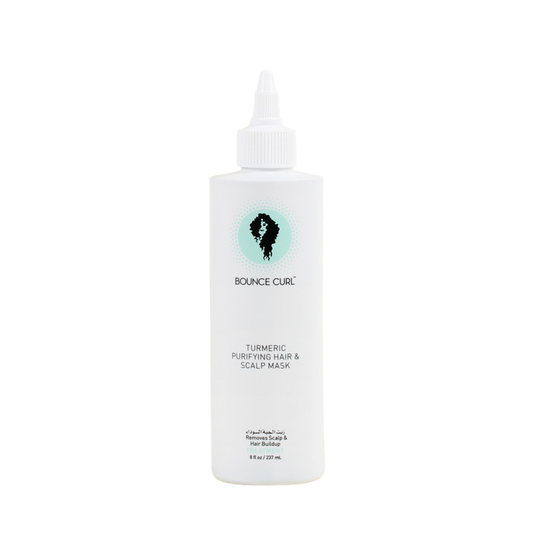 A white squeeze bottle of Bounce Curl Turmeric Purifying Hair & Scalp Mask with a pointed tip applicator