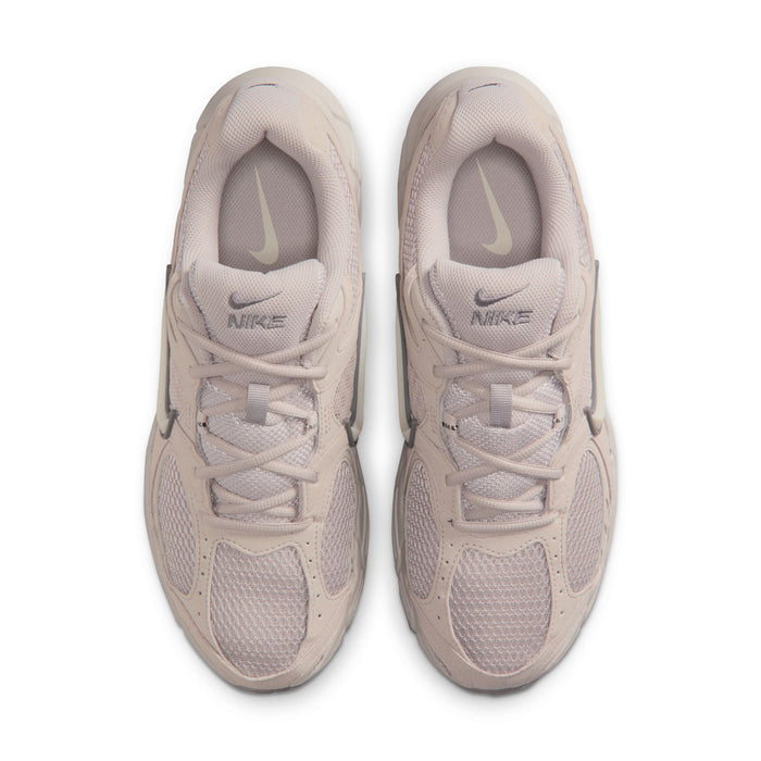 Men's beige Nike running shoes, rear view with padded collar and lace-up front.