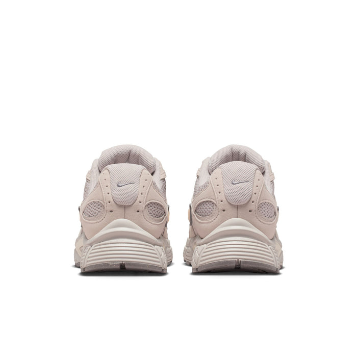 Men's beige Nike lace-up running shoes, heel view with rubber pods on outsole.