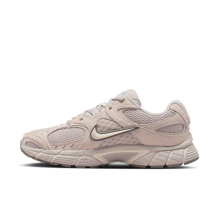 Men's beige Nike lace-up running shoes, profile view with swoosh and mesh upper.