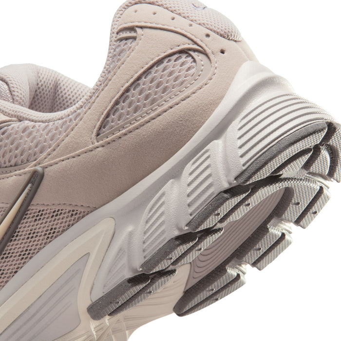 Men's beige Nike running shoe side close-up with laces, mesh, and ribbed sole.