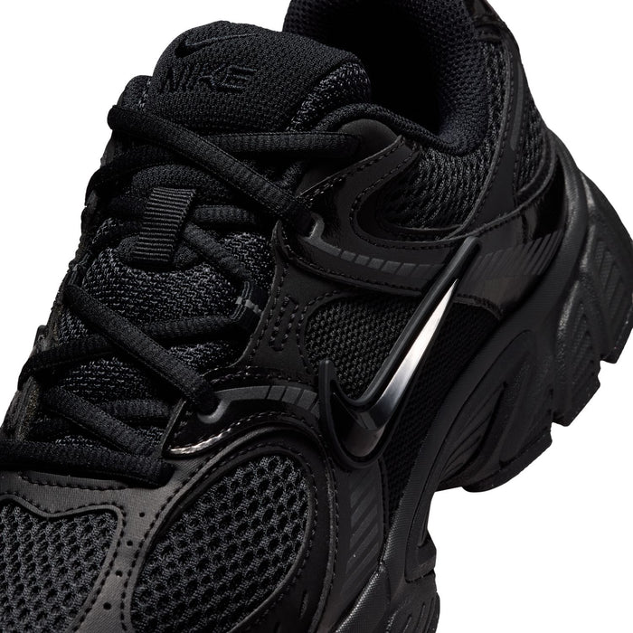 Black sneaker upper close-up with mesh, padded collar, strap details, and Nike Swoosh.