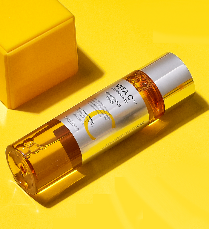 MISSHA Vita C Plus Brightening Toner bottle displayed on a vibrant yellow background, emphasizing its vitamin C formula for radiant and glowing skin.