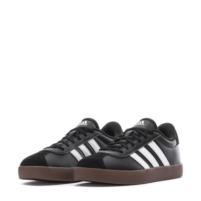 Pair of black youth court sneakers with white stripes and gum-brown outsole