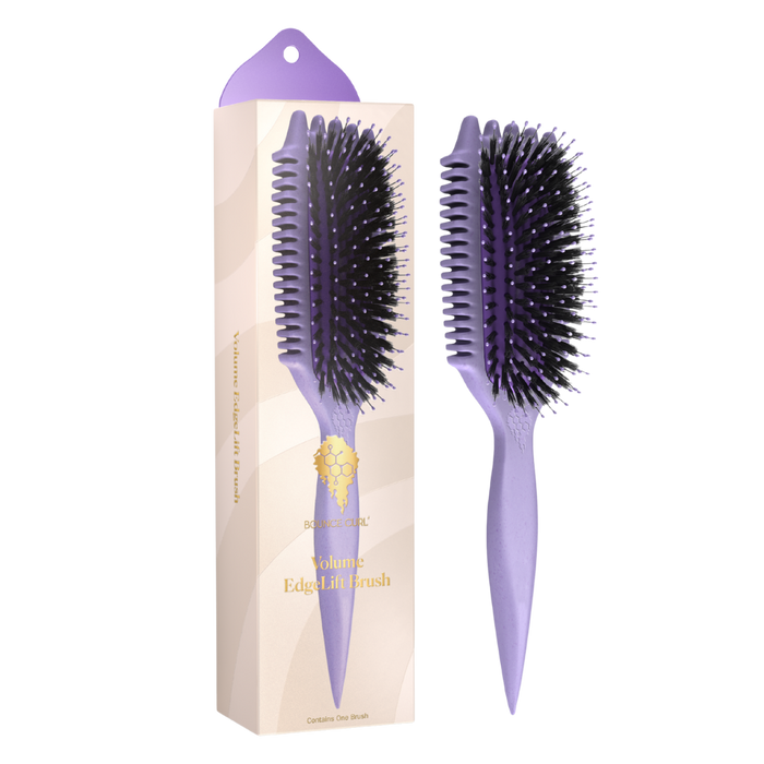 Purple hairbrush with black bristles next to its packaging on a white background