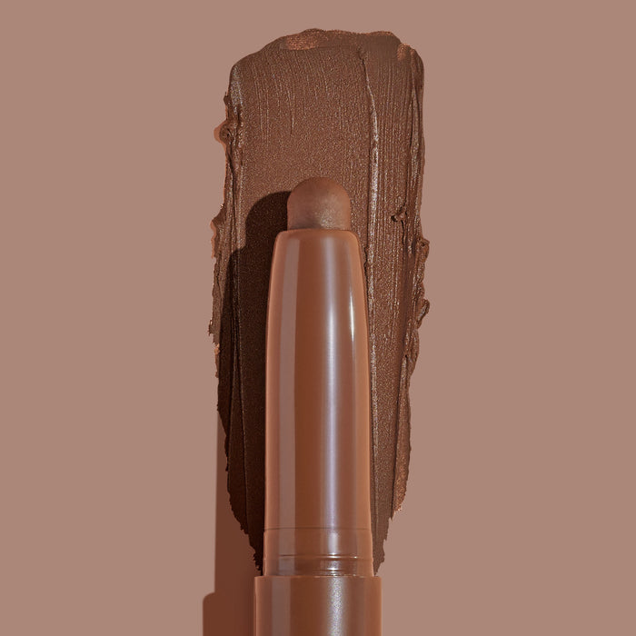 Walnut Ave ColourPop Shadow Stix sweeping a thick, matte walnut-brown swatch on a taupe background, showing the twist-up cream eyeshadow pencil tip and rich pigment payoff for easy, on-the-go eye color.