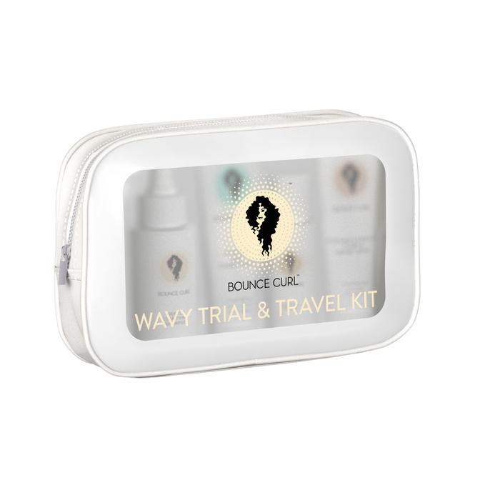 A clear zip pouch labeled Bounce Curl Wavy Trial & Travel Kit containing several small product bottles