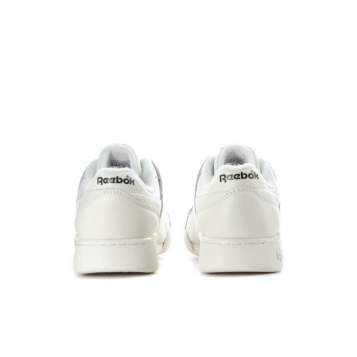 White low-top sneakers, back view, with Reebok heel branding.