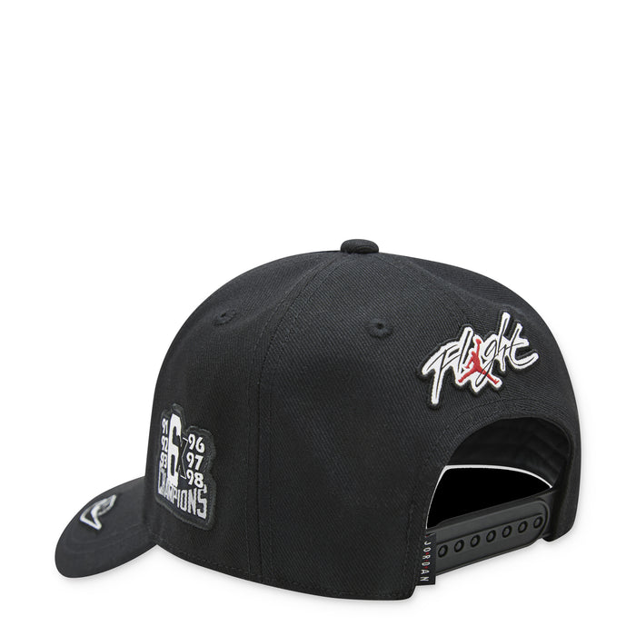 Youth Jordan black curved brim cap with side logo patch and red/black graphic